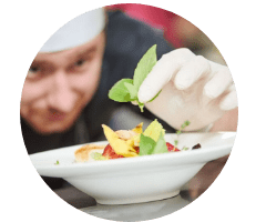 Koch dekoriert einen Teller im Restaurant – Branche, die vom Foodservice Frucht Hartmann beliefert wird.